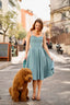 A redhead in Cannes wearing a sunhat and a blue cotton/linen Gaâla Bardot dress, lifting up the skirt to show a voluminous petticoat underneath.