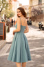 A redhead in Cannes wearing a blue cotton/linen Gaâla Bardot dress, playfully lifting up the skirt to show a petticoat underneath.