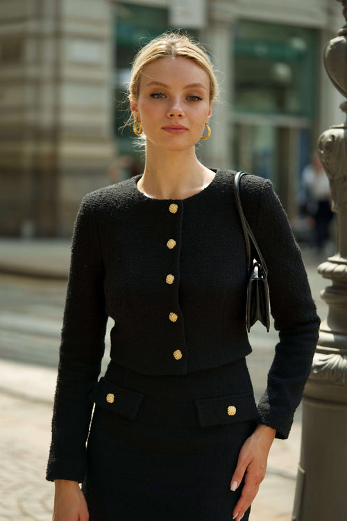 Model is wearing Chanel's complete ensemble, skirt, blouse, jacket