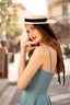 A redhead in Cannes wearing a sunhat and a blue cotton/linen Gaâla Bardot dress, lifting up the skirt to show a petticoat underneath.