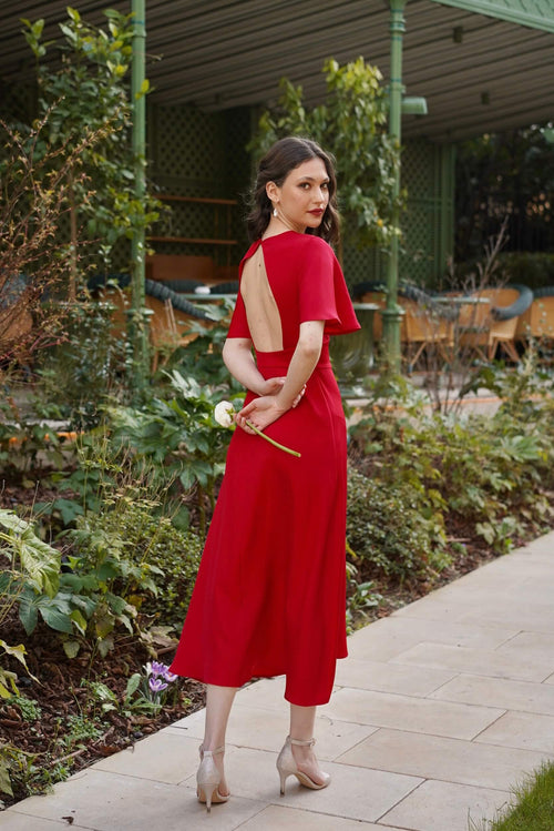 A girl in a red silk Gaâla dress moving around in Paris. 