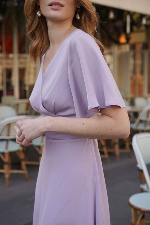 A redhead girl in cafe in Paris wearing a long silk lilac colored dress